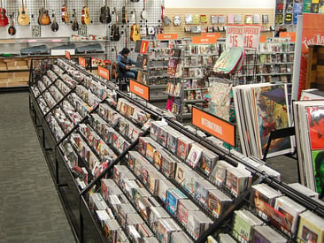 Store displays a long media display with CDs and slatwall and gridwall in the background