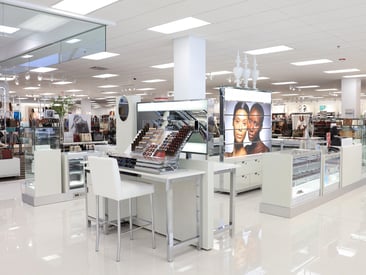 Store displaying an elegant makeup counter with makeup palettes and glass countertop showcases