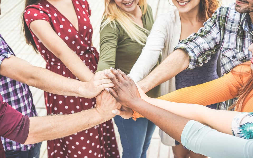 A group of individuals putting their hands together