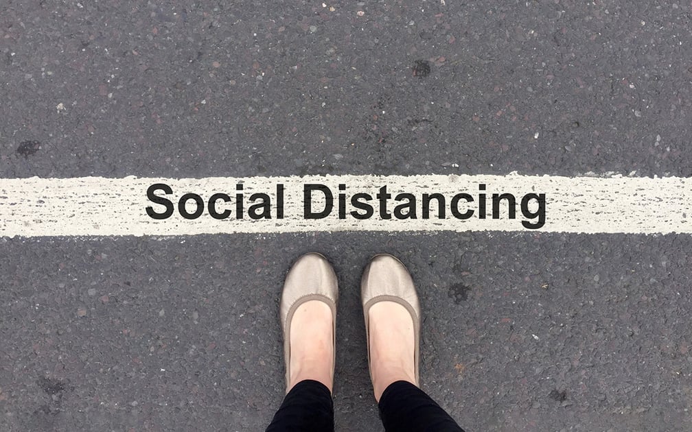 Displaying a line on the road with the words Social Distancing