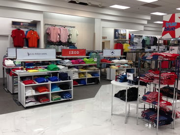 Store displaying tiered t-shirt displays and clothing racks