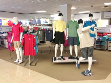 Store displaying mannequins and clothing racks with athletic wear