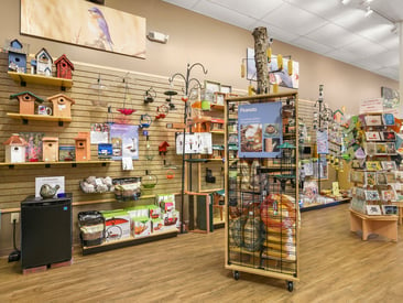 Store showing slatwall with bird feeders and bird houses.